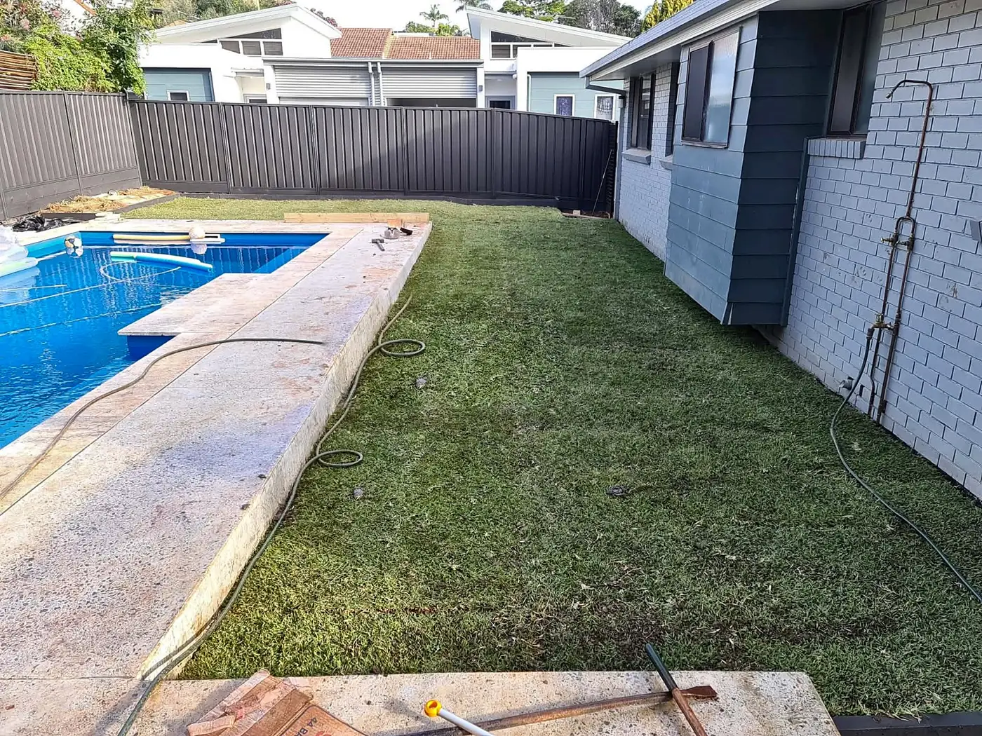 New turf laid along a pool with a clean edge